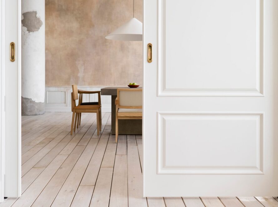 Vista de unas puertas correderas y al fondo se ve una mesa de comedor con sillas